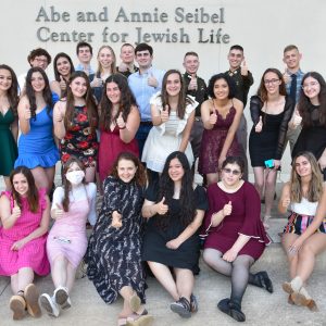 A group picture of students dressed up doing the gig em symbol