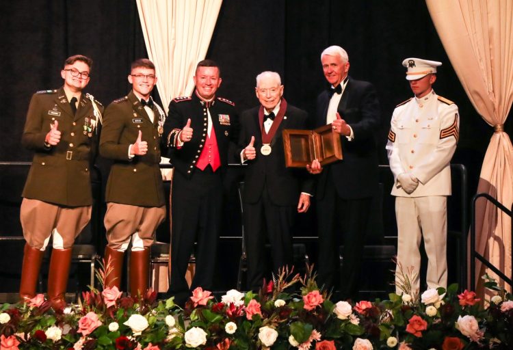On stage with Mr. Maltz is L-R: CCA Ambassador Charlton Bruton, Corps Commander John Andruss, Corps Commandant LtGen James Bierman, Mr. Maltz, CCA President & CEO Dr. Bruce Hamilton, and a member of the Ross Volunteer Company. Photo by AR Photography.